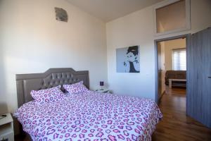 1 dormitorio con 1 cama grande y edredón rosa en ATW Apartments, en Amberes