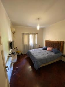 Dormitorio con cama, escritorio y TV en Departamento Av. España en Mendoza