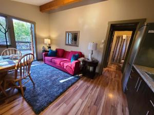 a living room with a red couch and a table at A Shack In The Woods in Port Renfrew