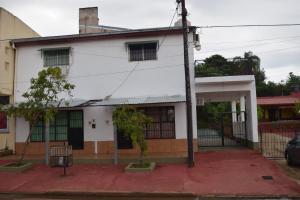 a white house with a fence in front of it at Departamento monoambiente vacacional in Posadas