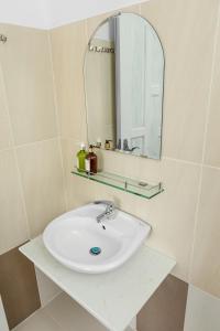 bagno con lavandino bianco e specchio di Caroline Resort a Vung Tau