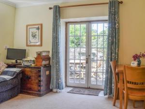 a living room with a door open to a patio at Ty Sally Jones in Bwlch
