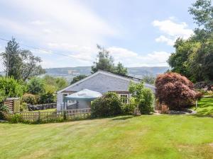 una casa con un patio con césped verde en Ty Sally Jones, en Bwlch