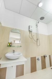 ein Bad mit einem Waschbecken und einem Spiegel in der Unterkunft Caroline Resort in Vũng Tàu