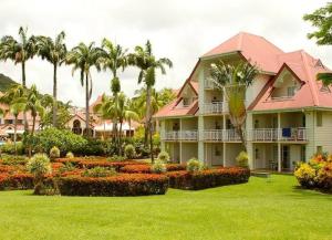 een resort met palmbomen en een tuin met bloemen bij Studio Tropical avec vue mer dans une résidence hôtelière in Sainte-Luce