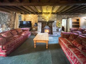 a living room with two couches and a fireplace at Duvale Barn in Bampton