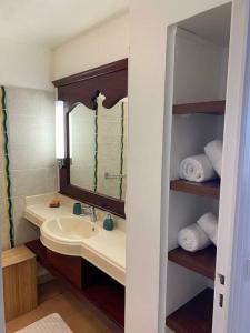 a bathroom with a sink and a mirror and towels at Studio Tropical avec vue mer dans une résidence hôtelière in Sainte-Luce