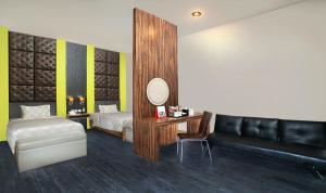 a bedroom with a bed and a desk with a mirror at Swiss-Belcourt Makassar in Makassar