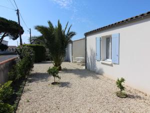 a yard with a house and a palm tree at Maison Saint-Georges-d'Oléron, 4 pièces, 6 personnes - FR-1-246A-172 in Saint-Georges-dʼOléron