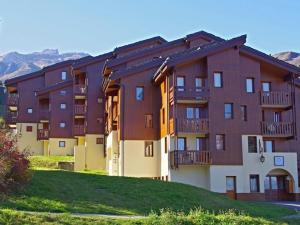 ein großes Apartmenthaus mit Balkon auf einem Hügel in der Unterkunft Appartement Valmorel, 2 pièces, 5 personnes - FR-1-291-886 in Valmorel