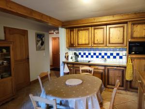 kuchnia ze stołem i krzesłami oraz kuchnia z drewnianymi szafkami w obiekcie Spacieux T3, 6 pers, calme, balcon, parking, casier à skis, navette à 150m - FR-1-572-278 w mieście Arâches-la-Frasse