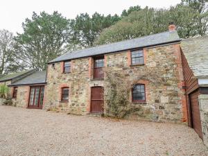 Cette ancienne maison en pierre est dotée de portes et de fenêtres rouges. dans l'établissement Barn Cottage, à Saint Erth