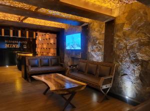 a room with two chairs and a table and a tv at Suites MINE in Mexico City