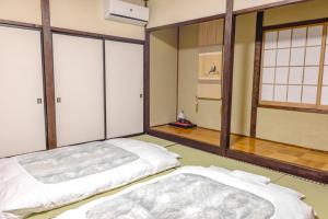 1 dormitorio con 2 camas en una habitación con ventanas en Lodge Amenouo, en Myoko