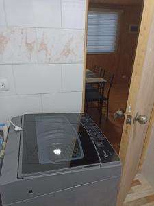 a microwave oven sitting in a kitchen with a table at Departamentos semiamoblado Puerto Montt in Puerto Montt
