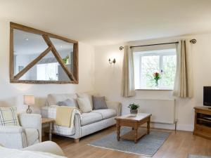 a living room with a couch and a mirror at Cherry Cottage - Ukc3990 in South Perrott