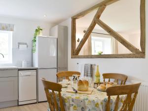 uma cozinha com uma mesa com uma toalha de mesa em Cherry Cottage - Ukc3990 em South Perrott