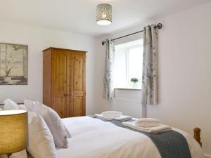 um quarto com uma cama branca e uma janela em Cherry Cottage - Ukc3990 em South Perrott