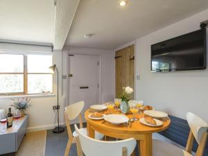 a dining room with a wooden table and chairs at Hogsnorting Villa in Blythburgh