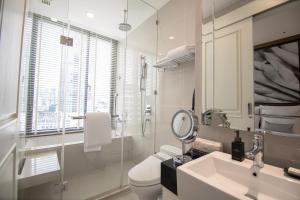 a bathroom with a toilet and a sink and a mirror at 137 Pillars Residences Bangkok in Bangkok