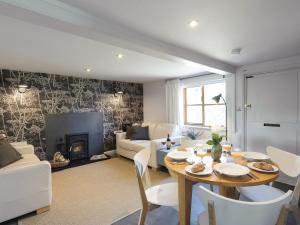 a living room with a table and a fireplace at Hogsnorting Villa in Blythburgh