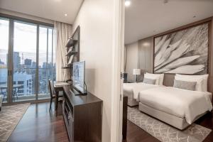 a bedroom with a bed and a desk with a television at 137 Pillars Residences Bangkok in Bangkok