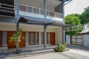 ein Gebäude mit einer Veranda und einem Balkon in der Unterkunft Reddoorz near Stadion Kridosono Blora in Blora