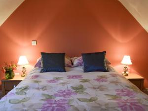 a bedroom with a large bed with two lamps at Boreham Bridge Barn in Ashburnham