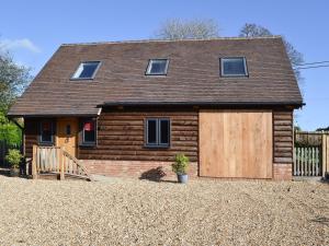 a house with a wooden garage in front of it at Boreham Bridge Barn in Ashburnham