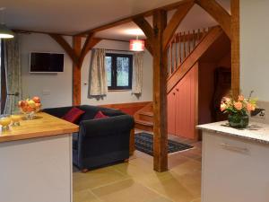 a kitchen and living room with a blue couch at Boreham Bridge Barn in Ashburnham