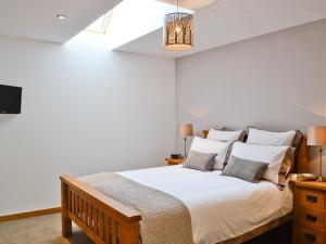 1 dormitorio con 1 cama con sábanas y almohadas blancas en Longcroft Dairy, en Oyne