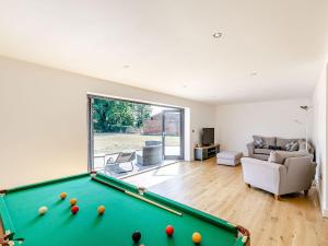 a living room with a pool table and a couch at Howell Hall Barn in Howell