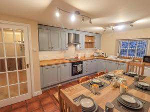 uma cozinha com uma mesa de madeira e uma sala de jantar em Lady Barn em Grange Over Sands