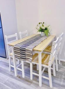una mesa de madera con sillas blancas y una planta en ella en Newly renovated! Minutes away from Mother's Beach and Main Street! en Mornington
