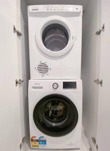 a washing machine with a dryer in a room at Newly renovated! Minutes away from Mother's Beach and Main Street! in Mornington