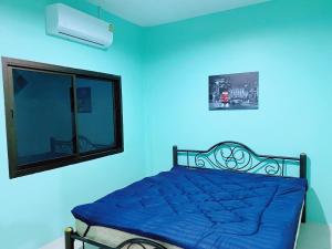 una camera blu con un letto e una finestra di Nature home a Ban Laem Hin