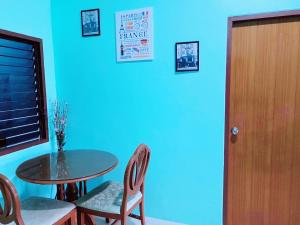 una sala da pranzo con tavolo, sedie e parete blu di Nature home a Ban Laem Hin