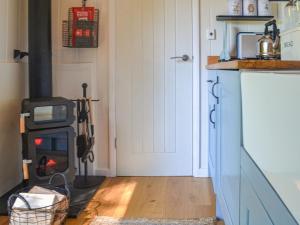 a kitchen with a wood stove in a room at Herdwick Hut in Twyn Llanan