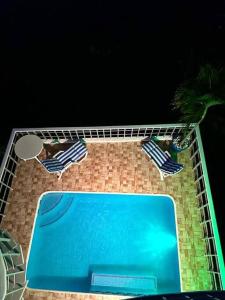 two chairs and a swimming pool at night at Casa Mykonos in Acapulco