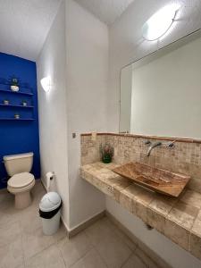 a bathroom with a sink and a toilet and a mirror at Casa Mykonos in Acapulco