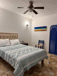 a bedroom with a bed with a ceiling fan at Casa Mykonos in Acapulco