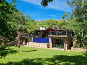 una vista exterior de una casa con un gran patio en Heysbrook Estate - Luxurious lodges in a private valley, en Waterval-Onder