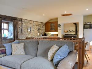uma sala de estar com um sofá e uma cozinha em The Cottage At Wilson House em Rokeby