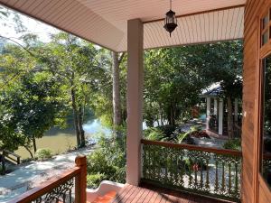 a screened in porch with a view of a river at Home of Dusita in Lamphun