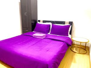 1 cama grande con sábanas moradas en una habitación en Wallaway2stay Gravit8 Klang 2 Plus 1Room, en Klang