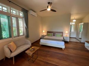 a bedroom with a bed and a couch at Home of Dusita in Lamphun