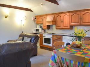 a kitchen with a couch and a table with a tablecloth at Wild Rose in Delabole