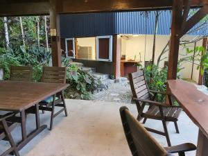 un patio con mesa de madera y sillas en Treeverb Beach House - Daintree en Cow Bay