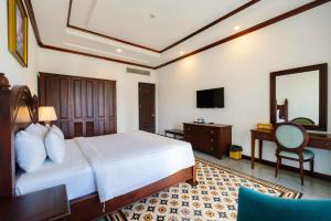 Schlafzimmer mit einem Bett, einem Schreibtisch und einem Spiegel in der Unterkunft Tahiti Resort in Phu Quoc
