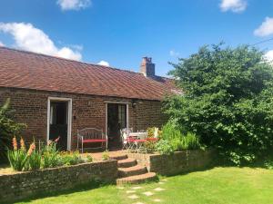 a brick house with a table and chairs in a yard at The Bothy in Staple